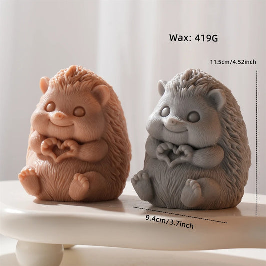 Two hedgehog-shaped figurines, one brown and one gray, on a white surface with measurements displayed.