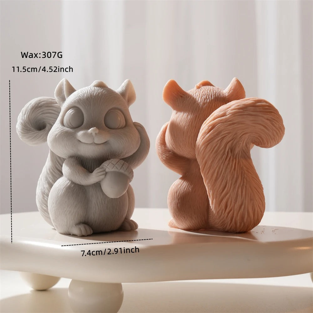 Two ceramic squirrel figurines, one gray and one brown, on a white surface with a light background.